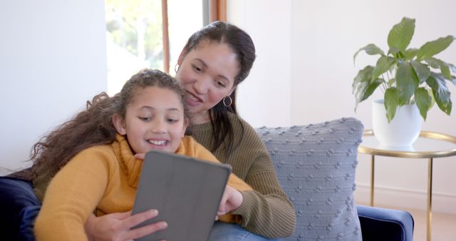 Mother and Daughter Using Tablet at Home Smiling Together - Download Free Stock Images Pikwizard.com