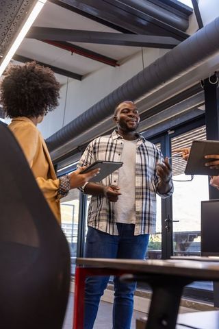 Diverse Team Collaborating in Modern Urban Office with Steel Beams