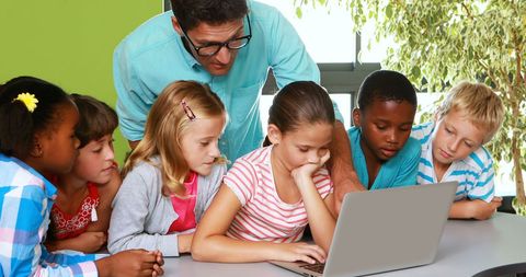 Teacher Guiding Diverse Students in Laptop Activity - Download Free Stock Images Pikwizard.com