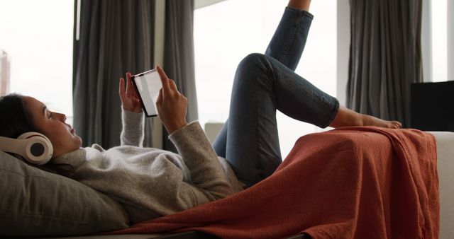 Relaxed Woman Lounging with Tablet and Headphones in Living Room - Download Free Stock Images Pikwizard.com