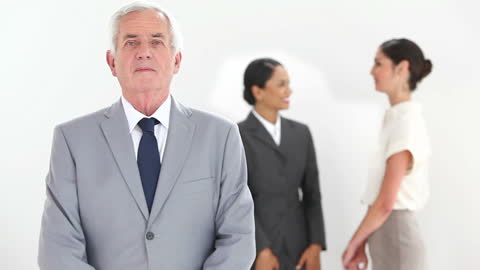 Confident Mature Executive with Dynamic Team in Discussion