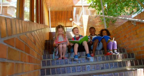 Diverse Children Reading Together on School Steps Outdoors
