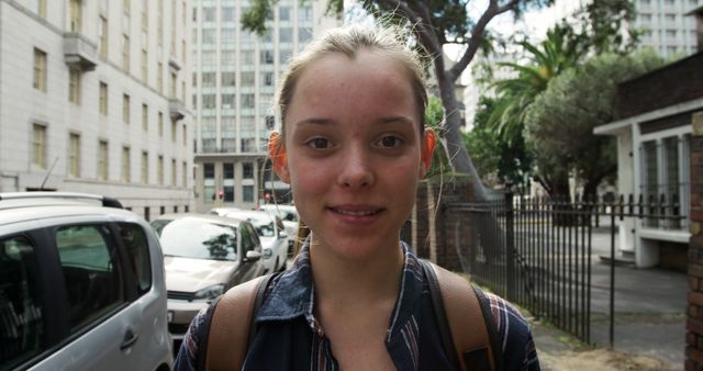 Smiling young woman in urban setting with buildings in background - Download Free Stock Images Pikwizard.com