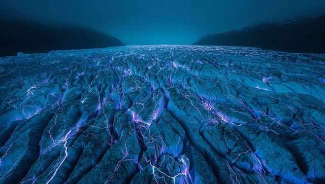 Glacier cracks glowing purple at twilight, neon crevasses stretching to horizon