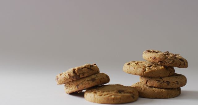 Image of two stacks of chocolate chip cookies on pale grey background with copy space. sweet, tasty snack food treat.