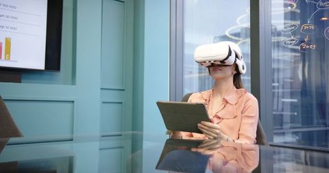 Woman Using VR Headset and Tablet in Modern Office
