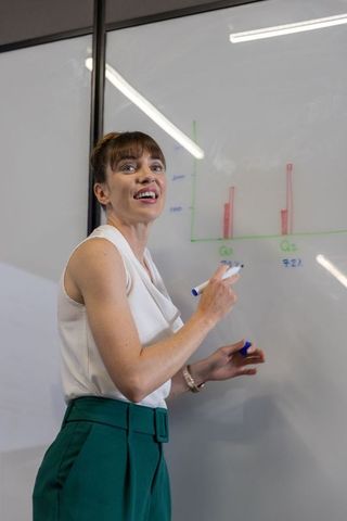 Businesswoman presenting bar chart data analysis in meeting room