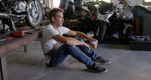 Motorcycle Mechanic Taking Break in Workshop - Download Free Stock Images Pikwizard.com