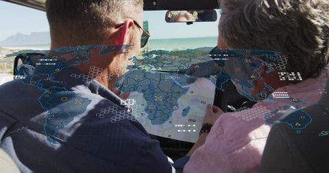 Studying road map with augmented reality overlays on windshield during coastal road trip