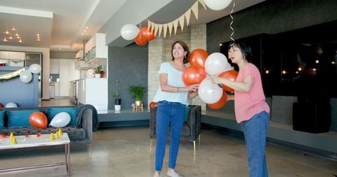 Senior Women Decorating Living Room for Birthday Celebration