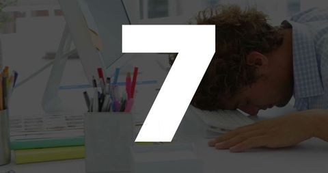 Exhausted office worker resting face-down on keyboard at desk