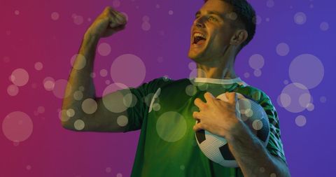 Excited Soccer Player Celebrating Victory in Colored Light