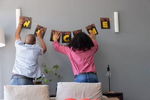 Couple Hanging Welcome Banner in Modern Living Room