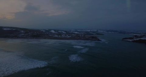 Twilight Waves Gently Lapping Snow-Capped Shoreline During Winter
