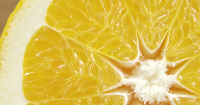 Close-up view of a freshly cut grapefruit slice showcasing its vivid pulp texture. Ideal for promoting healthy eating, nutrition, citrus fruits, and fresh food. Also suitable for use in culinary blogs, health articles, and fruit-based product advertisements.