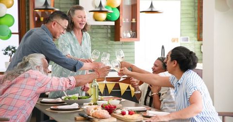 Senior Friends Celebrating with a Toast at Home Dinner Party