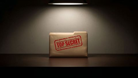 Top secret dossier under spotlight on wooden table dramatic noir chiaroscuro lighting