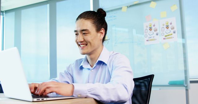 Young Professional Working on Laptop Smiling in Office - Download Free Stock Images Pikwizard.com