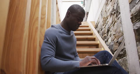 Man Using Laptop Sitting on Stairs at Home in Contemplation