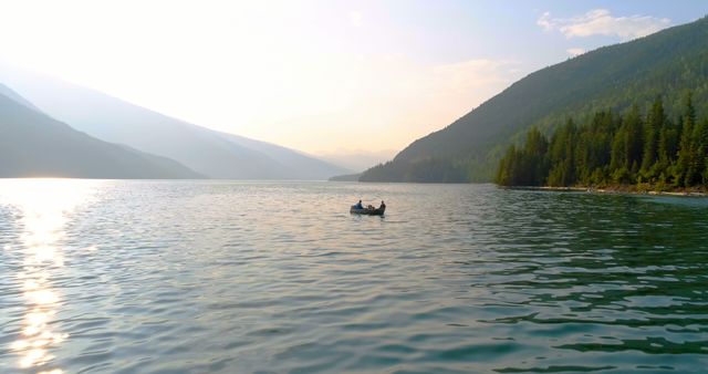 A serene lake surrounded by mountains under a soft sunset, with a small boat at the center. The tranquil setting suggests a peaceful retreat into nature, ideal for relaxation and contemplation.