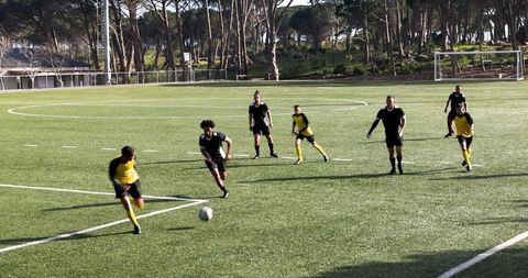 Youth Soccer Team Playing Energetic Match on Sunny Day