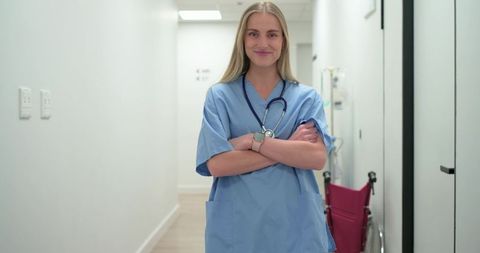 Female Nurse Standing Confidently in Clinic Corridor Wearing Scrubs and Stethoscope