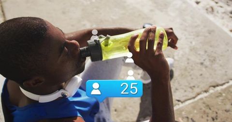 Athlete hydrating on urban steps after workout wearing headphones and neon bottle