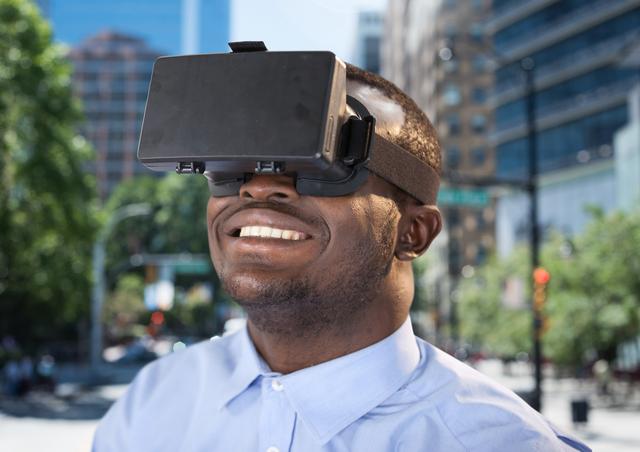 Man enjoying virtual reality experience outdoors in a bustling city environment. Ideal for use in technology, innovation, and entertainment contexts, as well as promoting VR products and urban lifestyle.