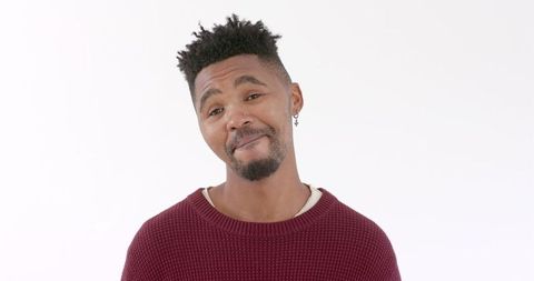 Confident Man Smiling in Casual Red Sweater Against White Background