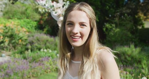 Smiling Woman in Sunlit Garden During Outdoor Event - Download Free Stock Images Pikwizard.com