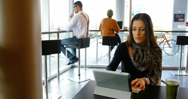 Young woman using tablet in modern coffee shop, working remotely - Download Free Stock Images Pikwizard.com