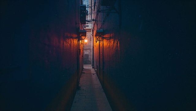 Narrow alleyway with warm lantern glow and industrial atmosphere