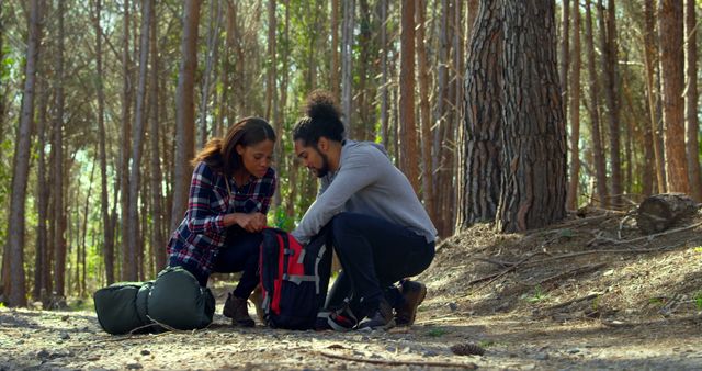 Young couple checking hiking backpack in the forest. Couple camping in the forest 4k