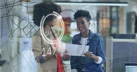 Reviewing document with hud overlay, two colleagues collaborating in modern office