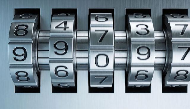 Precision rotating combination lock dials on brushed steel mechanism showing numeric code