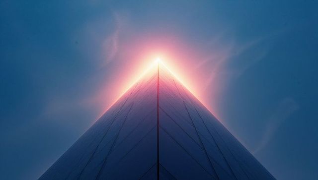 Futuristic monument glowing under sky with lens flare effects