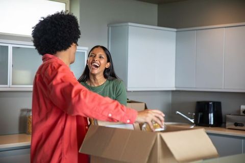 Joyful Couple Unpacking in New Home Kitchen