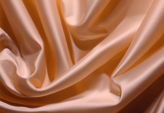 This image captures the elegance of golden silk fabric with subtle folds creating a luxurious feel. Perfect for backgrounds on websites, fashion design concepts, textile advertisements, and interior decor ideas. Useful for presentations, social media posts, marketing materials, and more, providing a sense of sophistication and class.