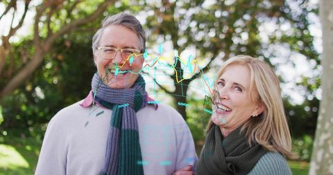 Mature couple linking arms and smiling in park with holographic finance charts overlay