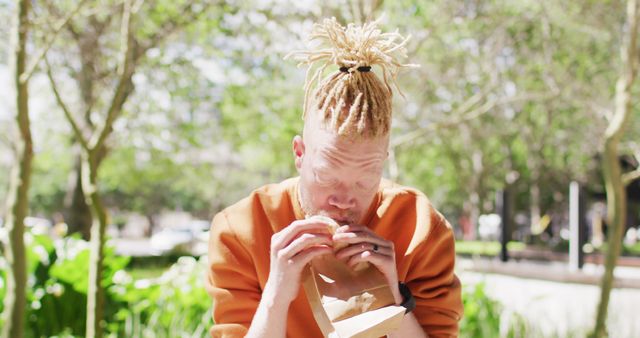 Person with Dreadlocks Enjoying Outdoor Meal in Park - Download Free Stock Images Pikwizard.com