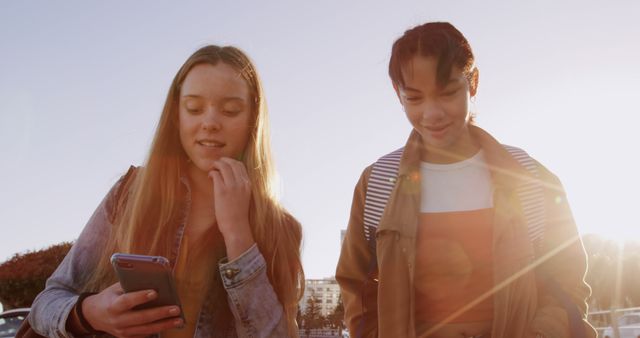 Teen Girls Engaged with Smartphones Outdoors on Sunny Day - Download Free Stock Images Pikwizard.com