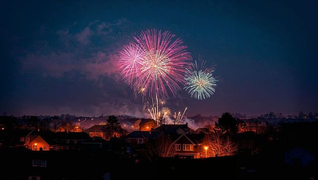 Colorful fireworks display over suburban neighborhood night