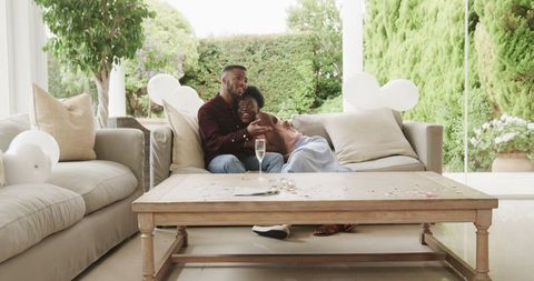 Couple Relaxes in Sunlit Living Room, Surrounded by Balloons