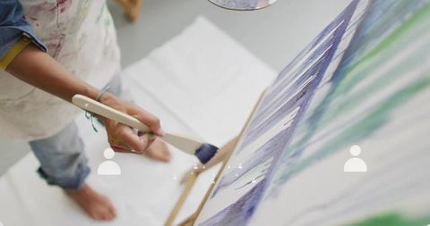 Artist creating abstract painting on canvas with brush strokes
