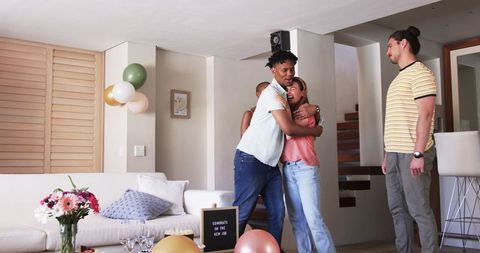 Friends celebrating new job at home with joy and balloons