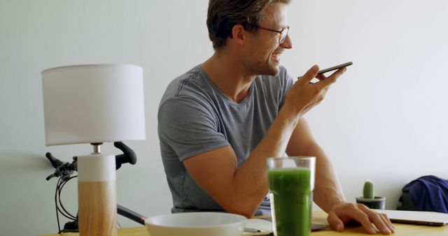 Smiling Man Using Smartphone for Voice Command in Home Office - Download Free Stock Images Pikwizard.com