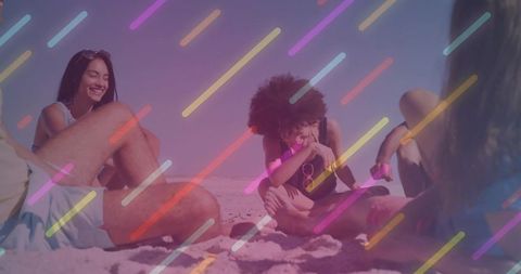 Young friends laughing and relaxing on sunny beach with colorful neon light overlay