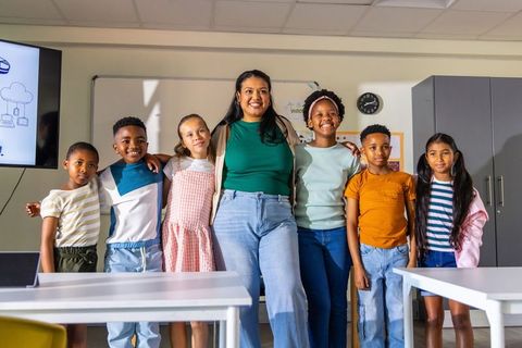Hispanic teacher leading diverse elementary students showing teamwork, joy, and learning