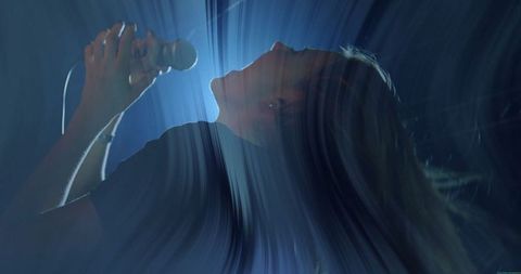 Silhouetted Female Singer in Dynamic Concert Lighting