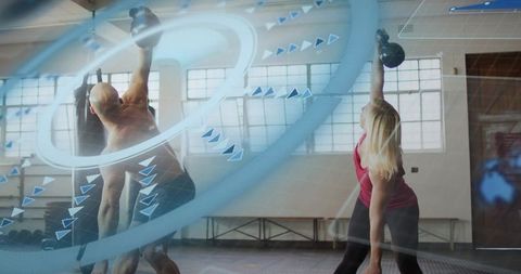 Dynamic kettlebell training duo performing overhead presses in industrial gym studio